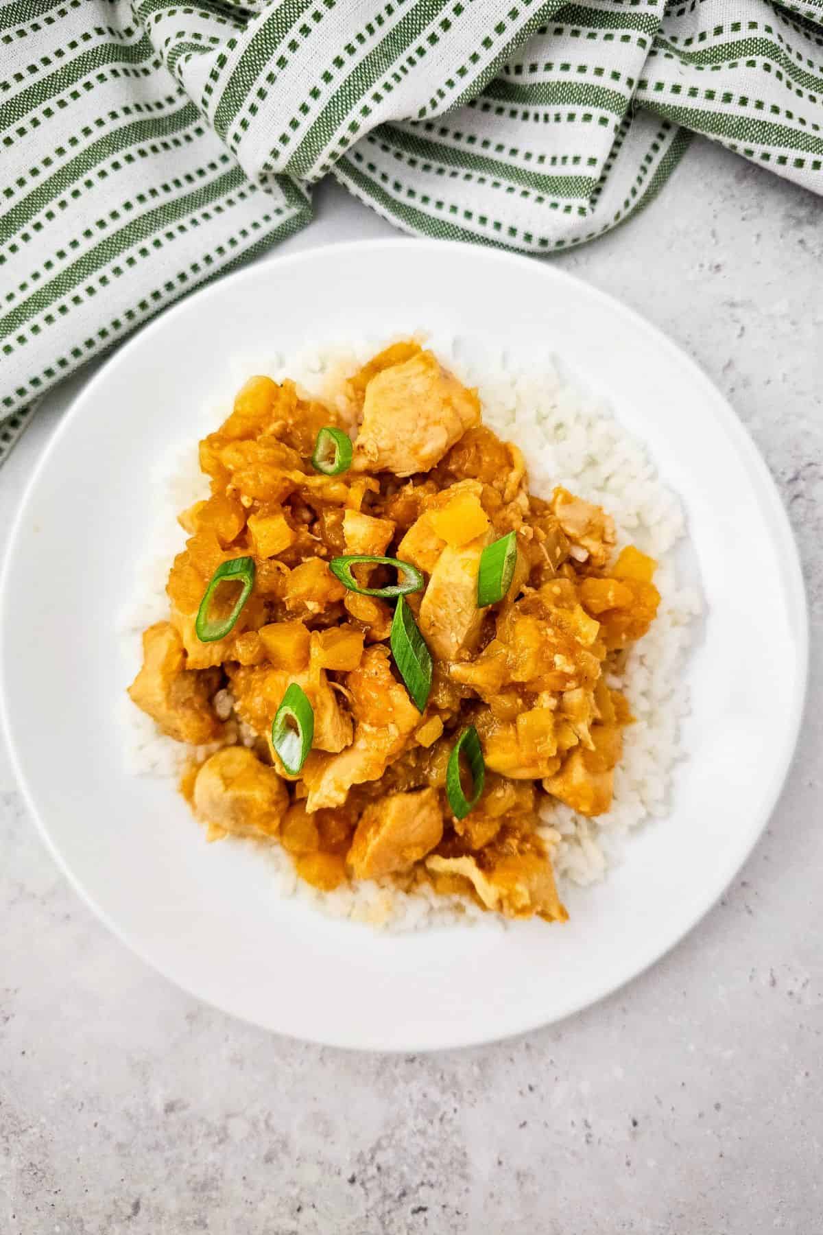 Delicious chicken and veggie stir-fry served over rice with fresh green onion garnish.