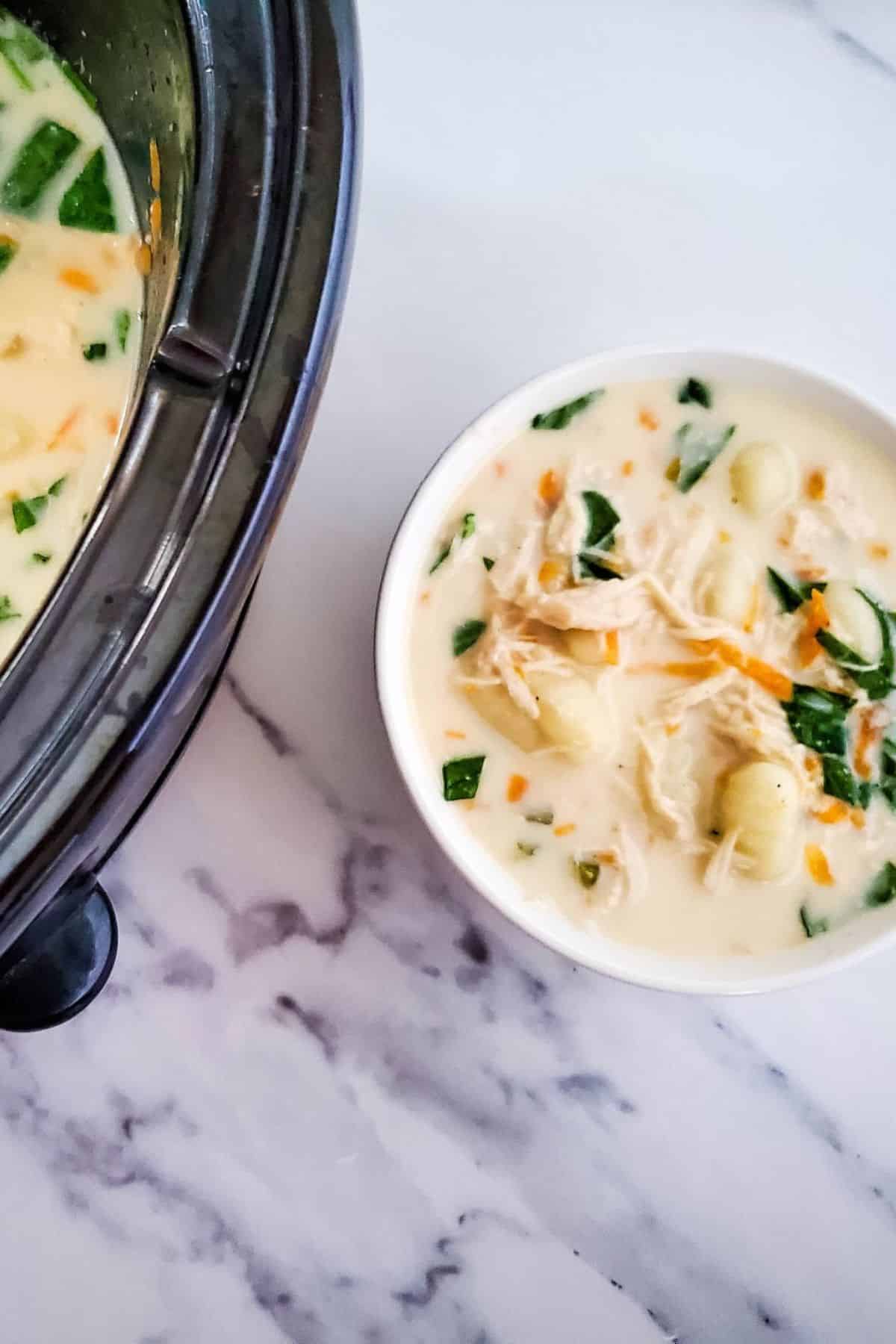 Comfort food: homemade creamy chicken soup with vegetables served in a white bowl.