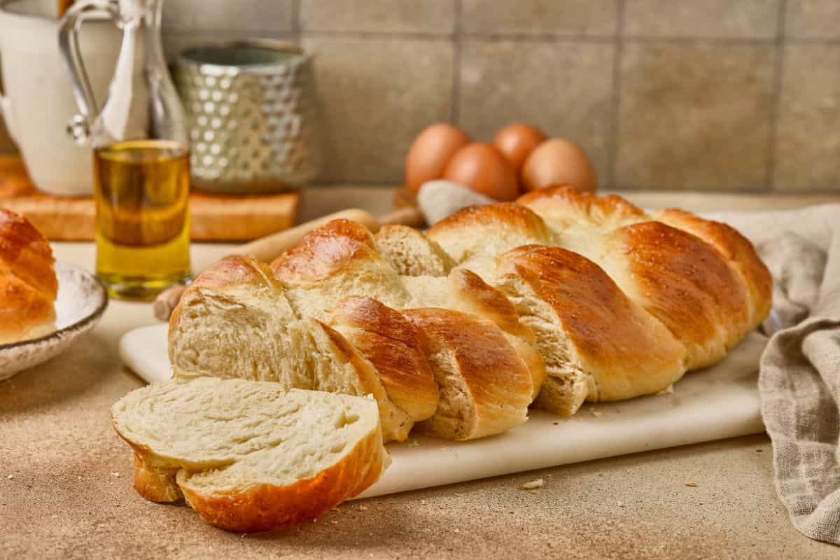 Delicious homemade bread sliced and ready to serve with ingredients nearby.
