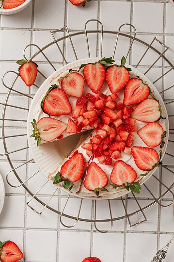 Delicious layered strawberry cake topped with fresh strawberries and diced berries. Perfect for celebrations.