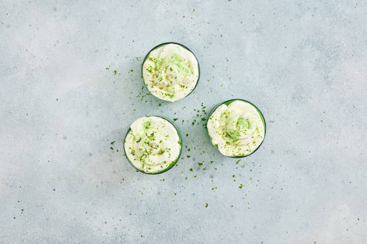Fresh cucumber drinks garnished with lime zest, vibrant and refreshing.