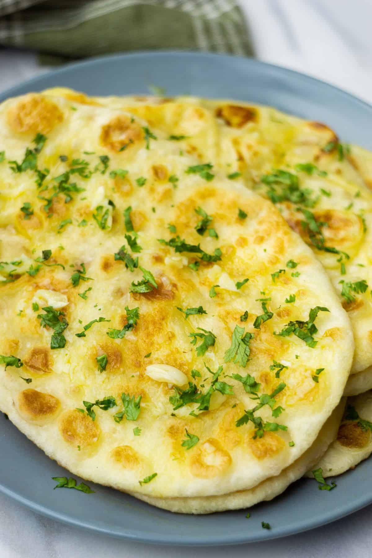 Delicious homemade naan bread topped with melted cheese, garlic, and fresh herbs, perfect for sharing.