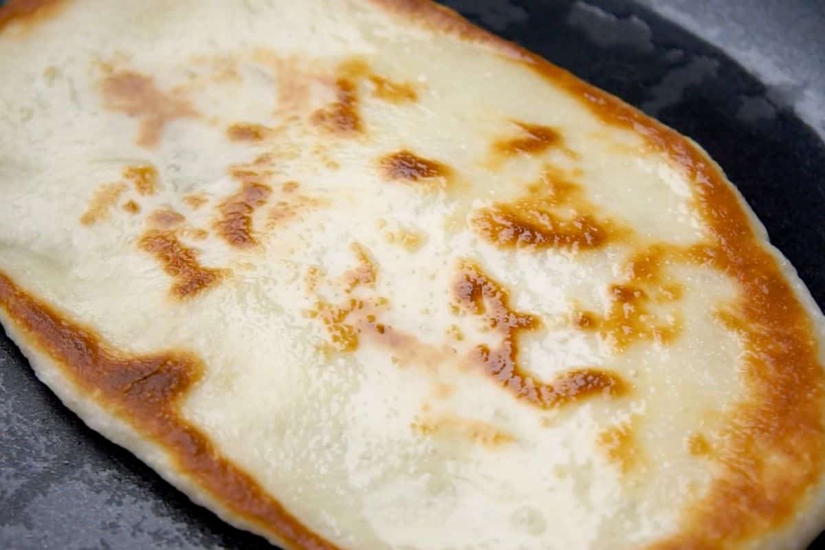 Cheese pizza slice baking with melted cheese and crispy golden crust, ready to serve.