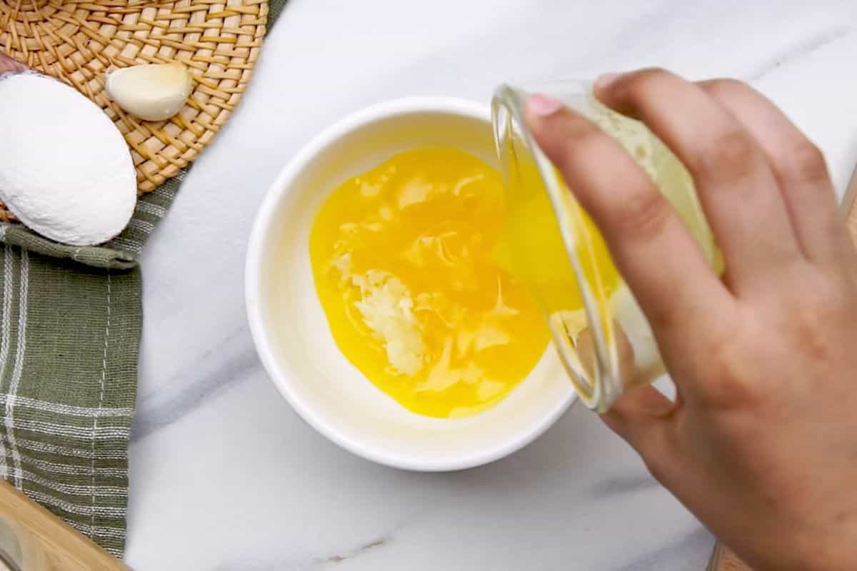 Fresh eggs being cracked into a white bowl, ready for cooking.