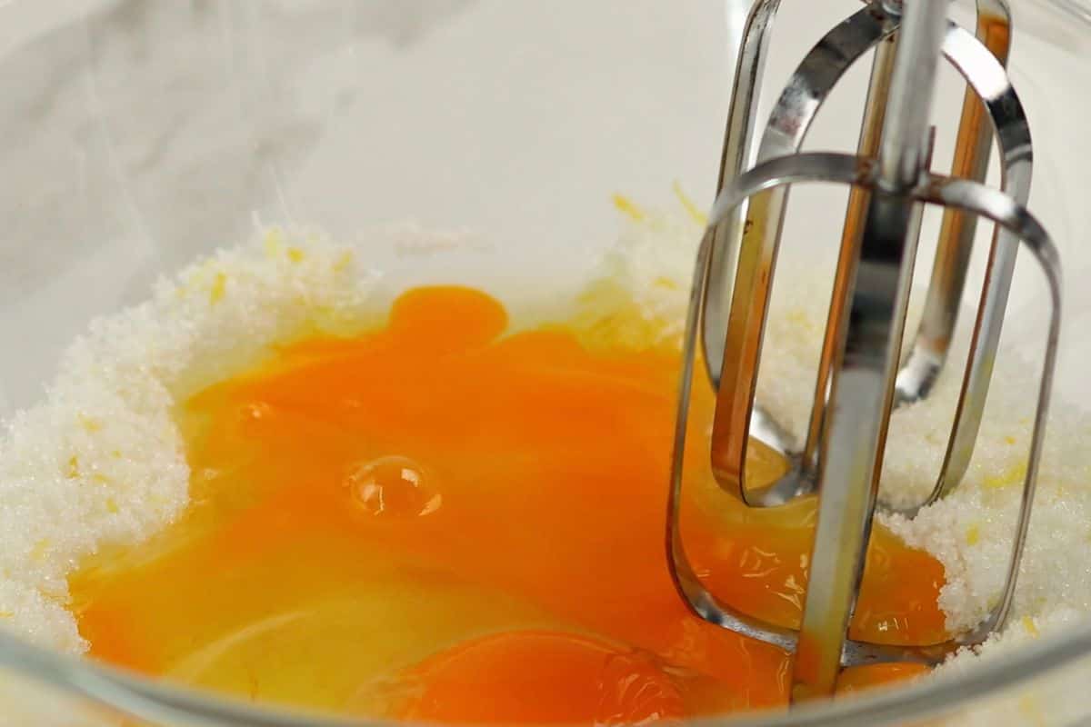 Mixing eggs into cake batter for baking or cooking. Perfect for desserts and breakfast recipes.