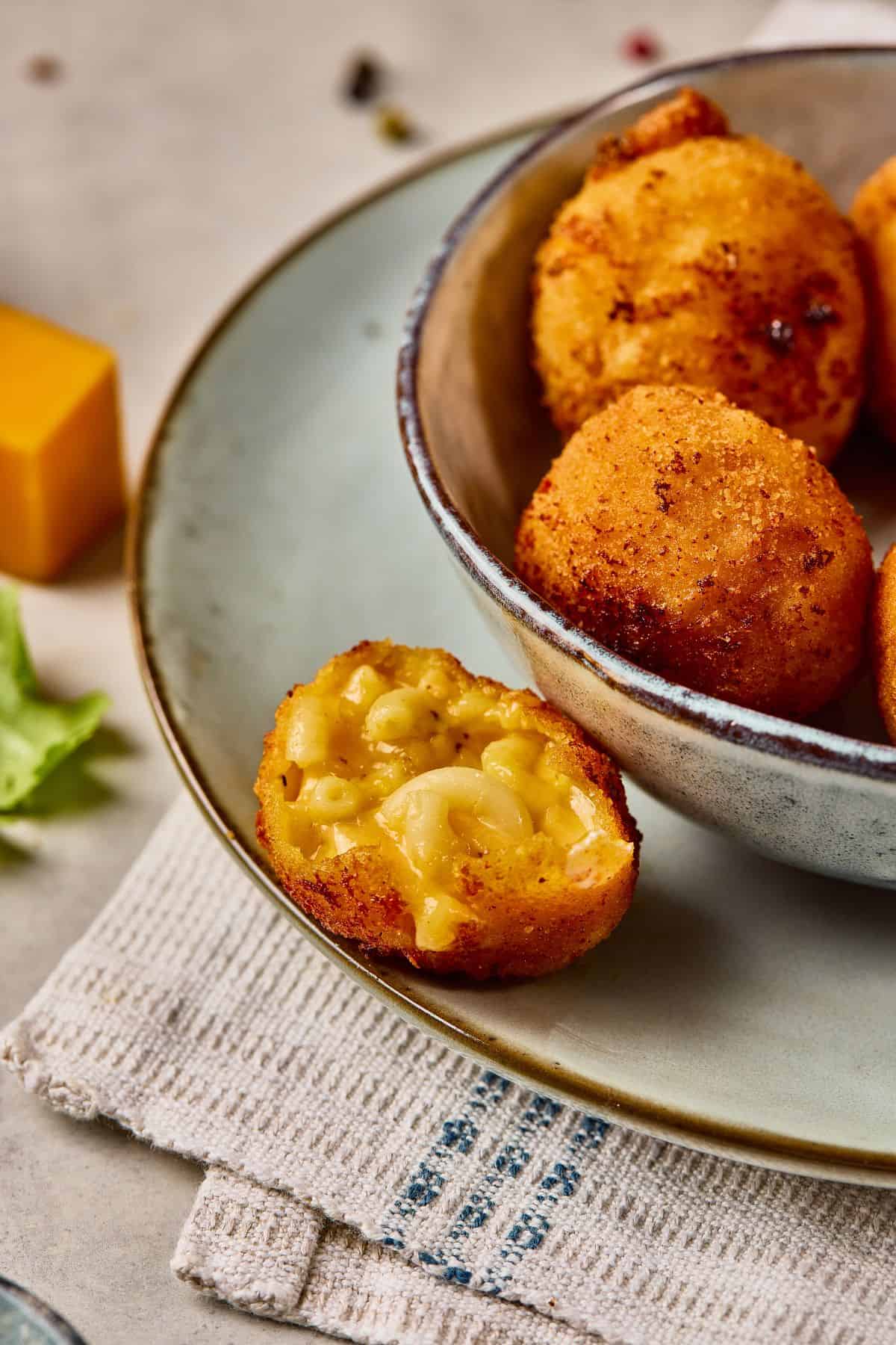 Golden deep-fried mac and cheese balls served with creamy melted cheese filling.