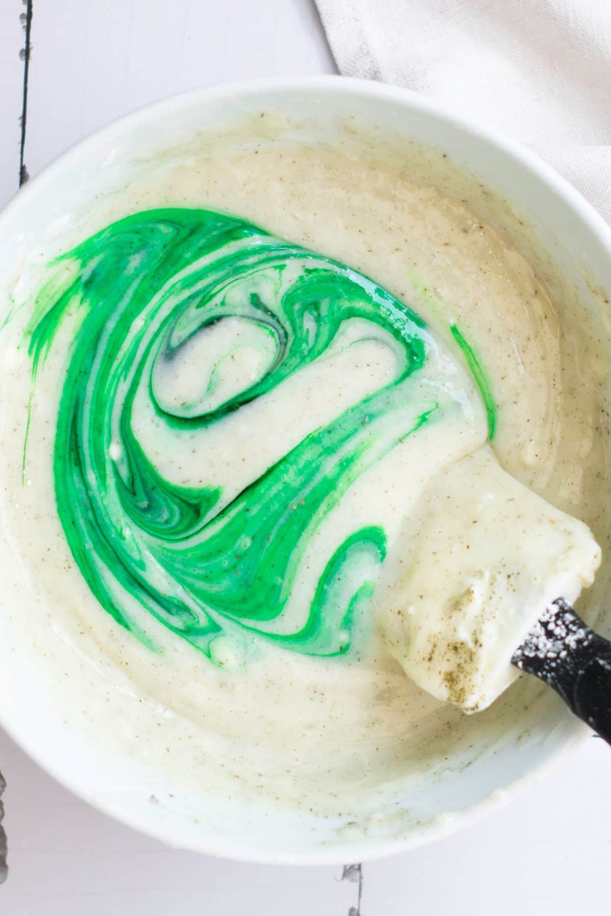 Bright, fun marble cake batter with green food coloring in a mixing bowl.