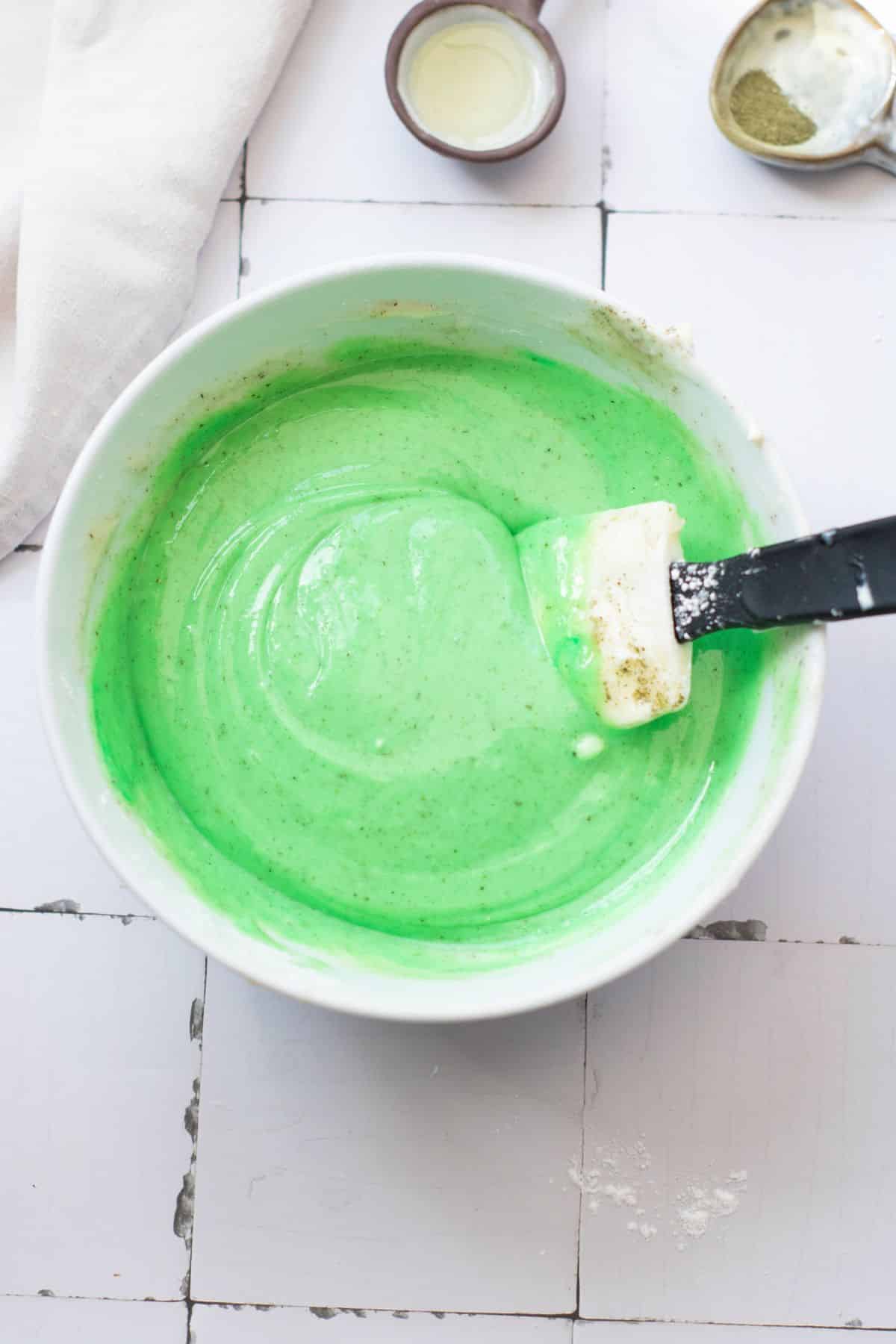 Bright green cake batter in a mixing bowl before baking.