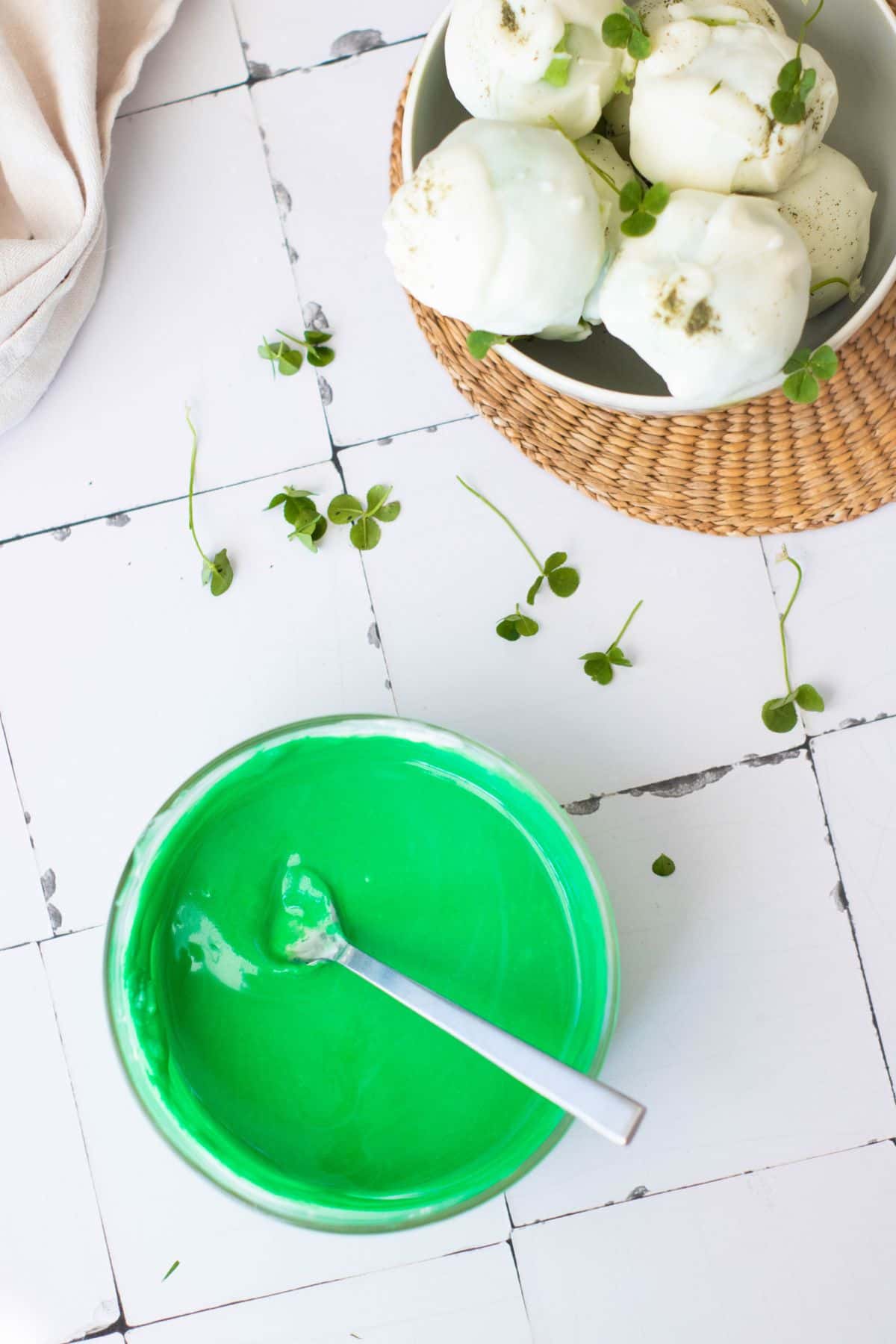 Cheese balls garnished with microgreens served on a white plate with a textured placemat.