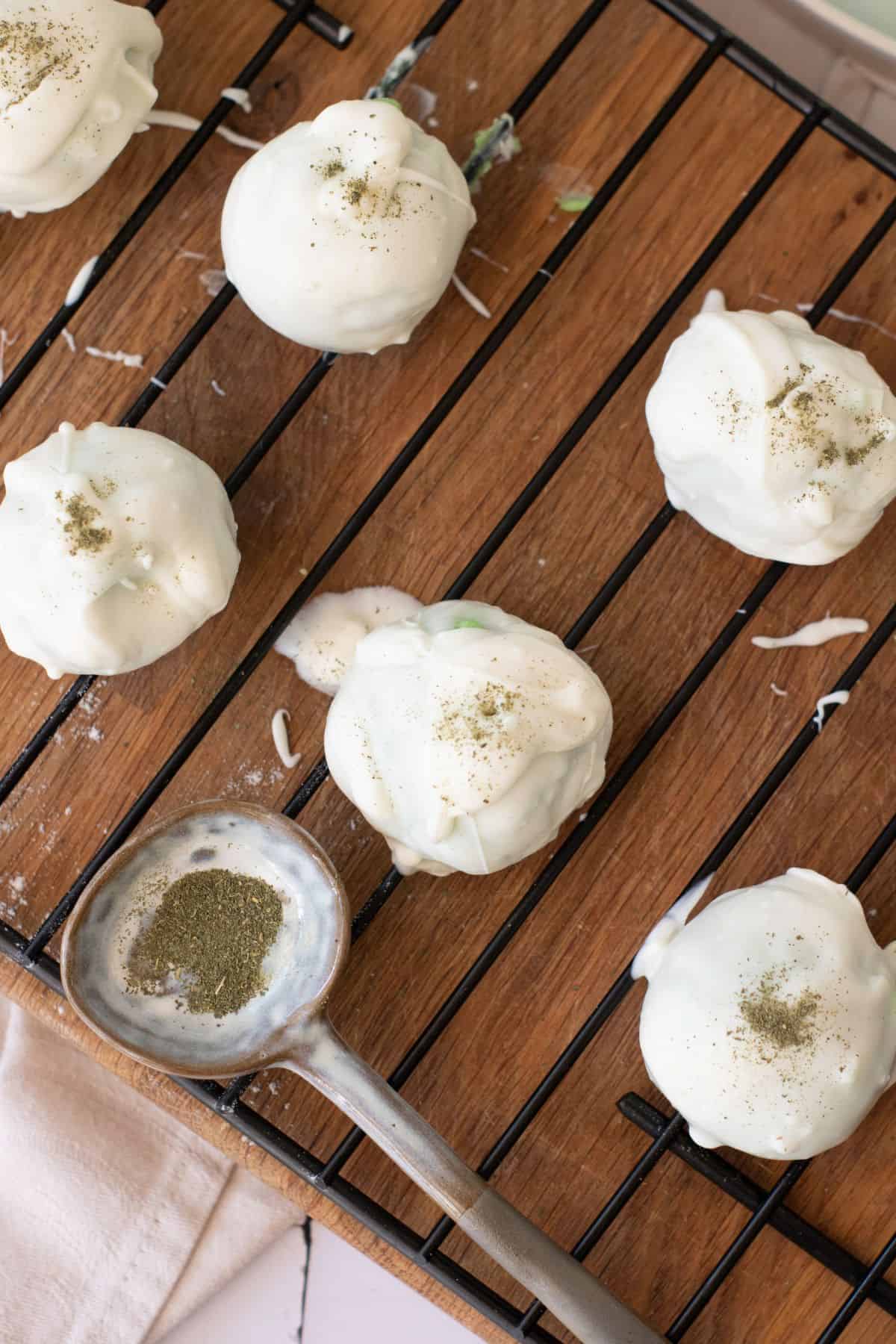 Feta cheese stuffed green peppers sprinkled with herbs on a wire rack.