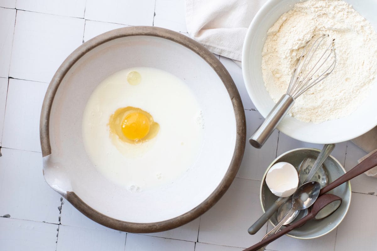 Bright kitchen with eggs, flour, and utensils for baking.