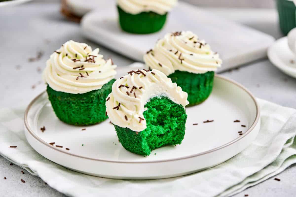 Delicious green velvet cupcakes with white frosting and chocolate sprinkles. Perfect for holiday celebrations.