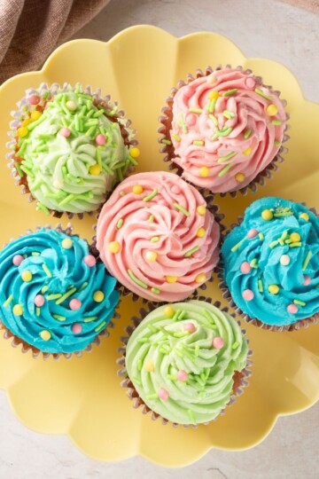 Bright, fun cupcakes decorated with pink, green, and blue frosting and colorful sprinkles.