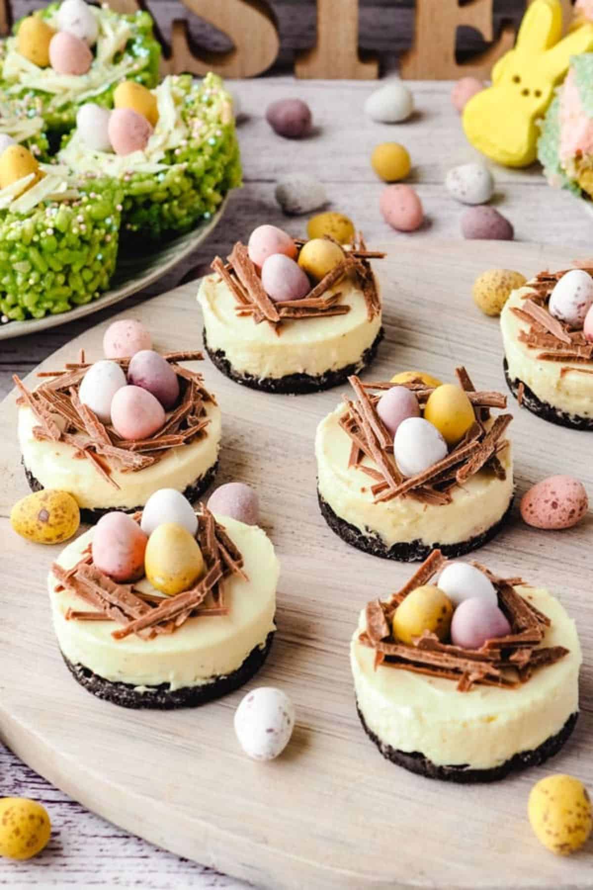 Delicious mini Easter cheesecakes topped with chocolate shavings and pastel candy eggs.