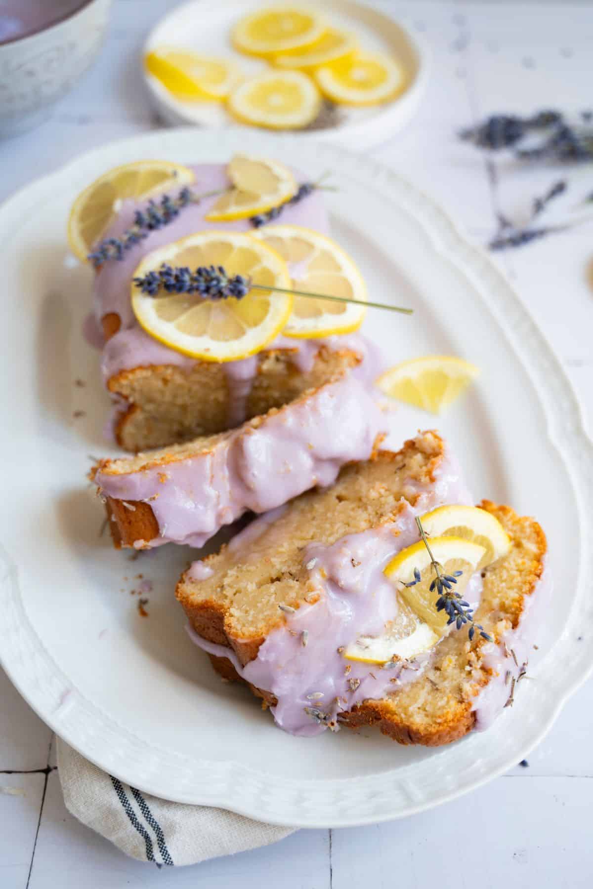 Delicious lemon drizzle cake topped with fresh lemon slices and lavender, perfect for spring celebra.