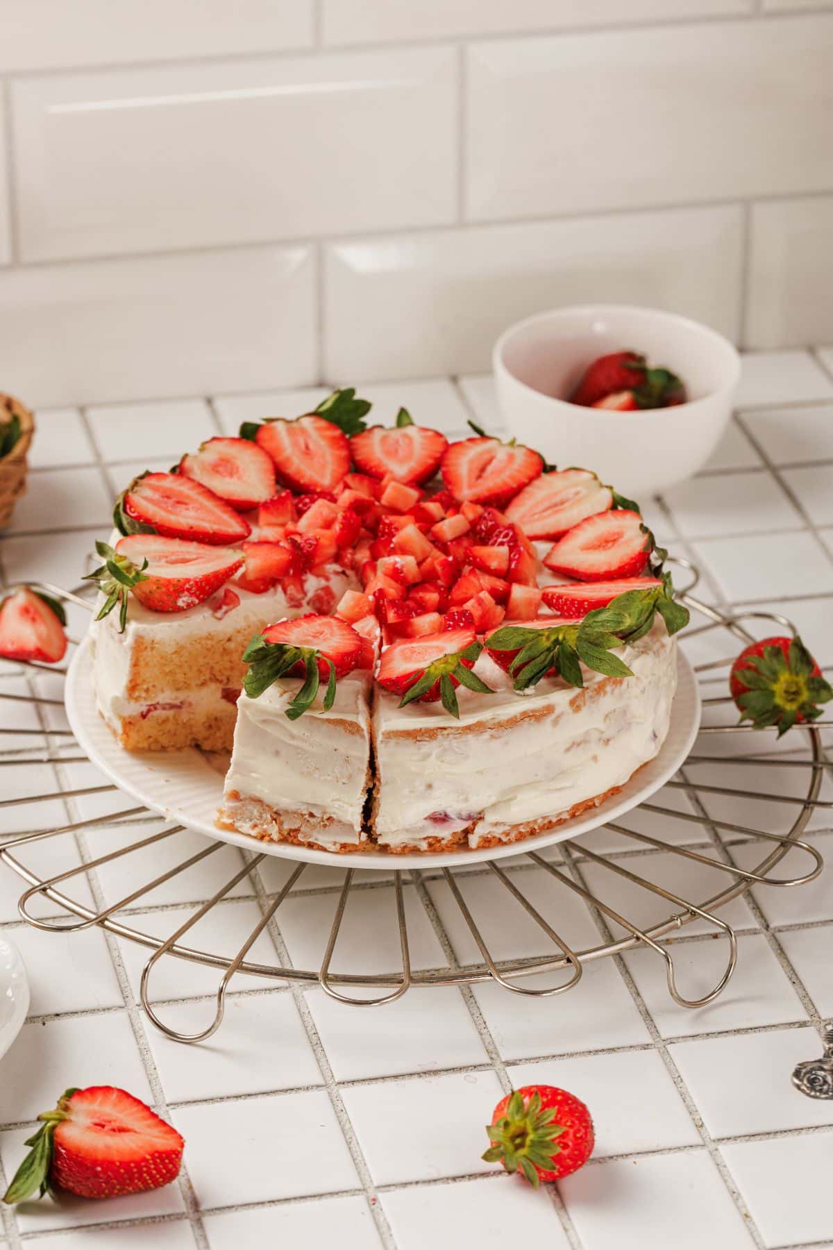 Delicious strawberry cake topped with fresh sliced strawberries and mint leaves.