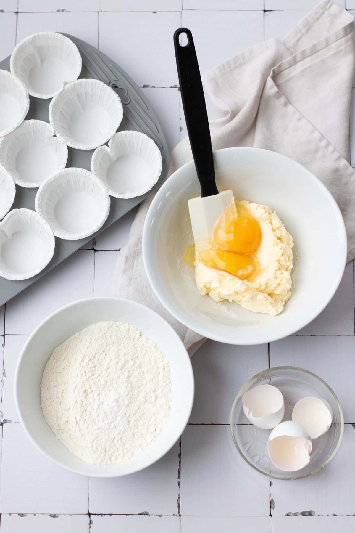 Bright white cupcake liners, flour, eggs, and butter for St. Patrick's Day cupcakes.