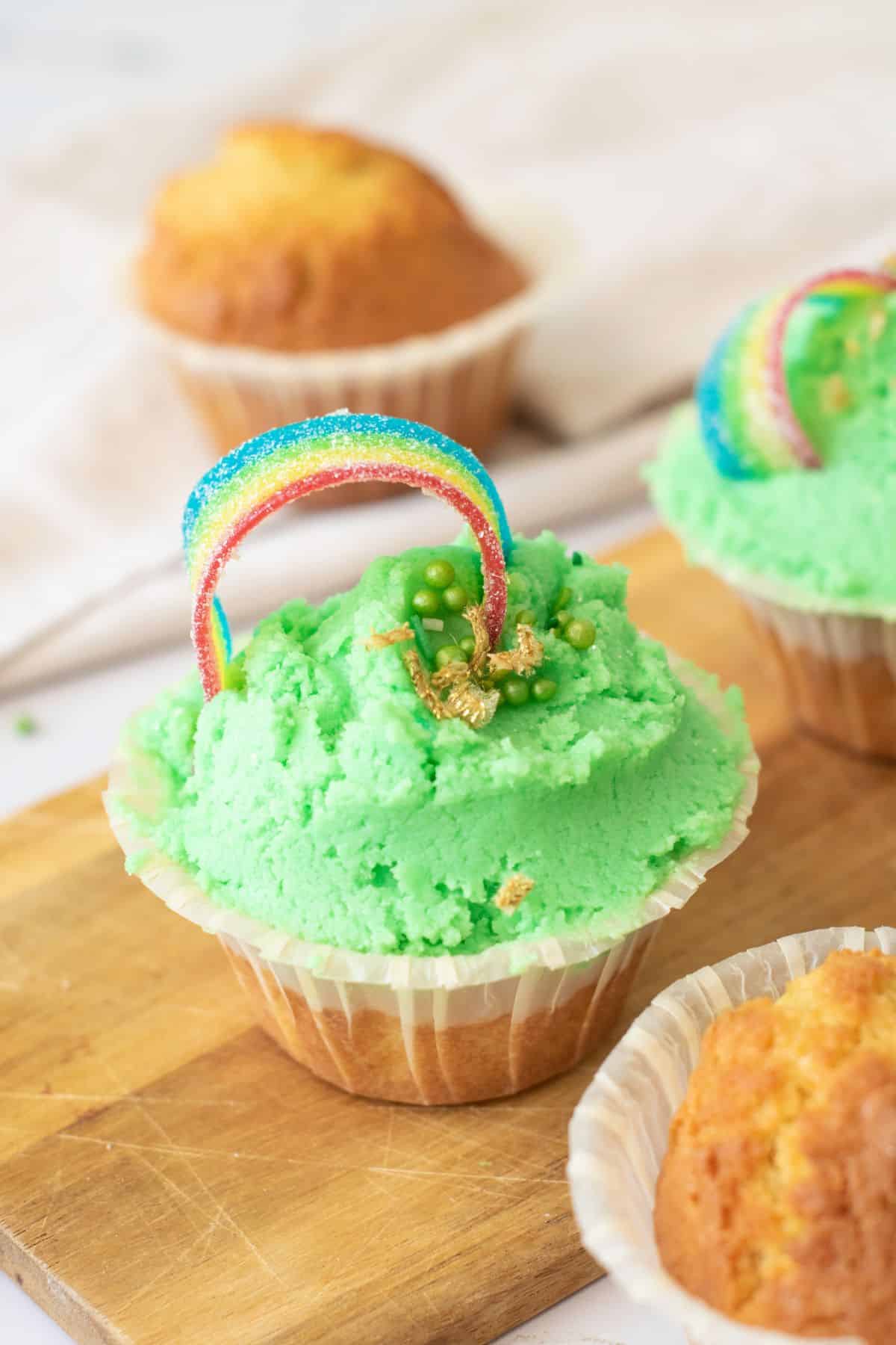 Colorful St. Patrick's Day cupcake with rainbow and gold accents for holiday celebration.
